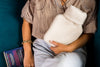 A woman cuddling a hot water bottle
